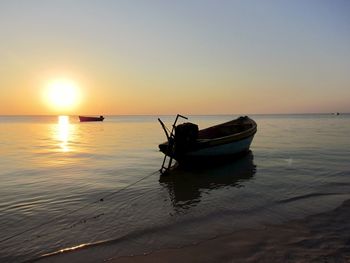 Boat in sea against sky during sunset