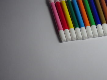 High angle view of multi colored pencils on white background