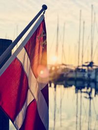 Close-up of danish flag against sky during sunset