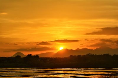 Scenic view of silhouette trees against romantic sky at sunset