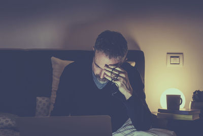 Man works with laptop lying on bed. male home working remote office sitting in bedroom use devices