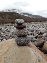Stack of pebbles on beach against sky