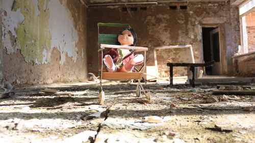 Doll on chair in abandoned house