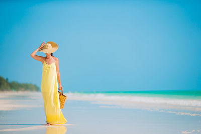 Woman standing on beach against sky