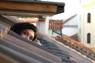 Woman looking through window on building