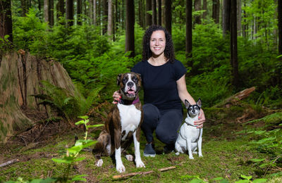 Portrait of dog standing by trees in forest