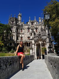 Portrait of woman sitting against palace