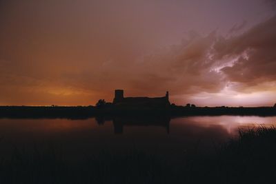 Scenic view of lake against orange sky