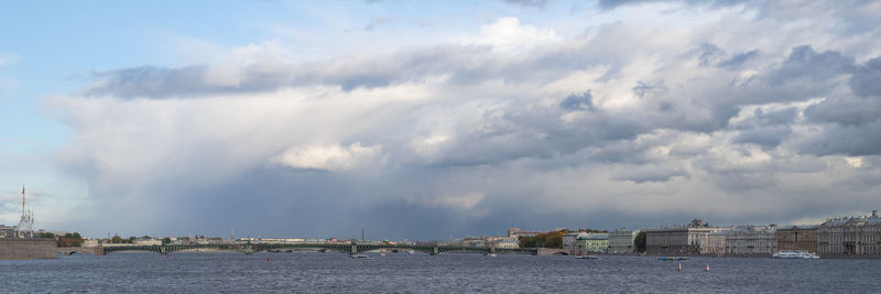 Panoramic view of buildings by sea against sky