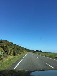 Road against clear blue sky