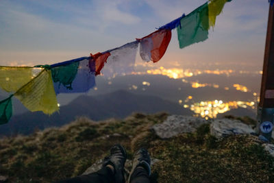 Low section of multi colored flags hanging against sky