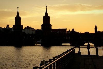 Oberbaum bridge over spree river against sky at sunset