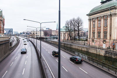 Traffic on road in city against sky