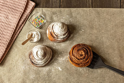 Freshly baked cinnamon pastry buns, sprinkled with powdered sugar and pastry topping.