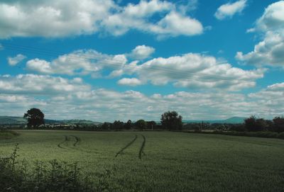 Scenic view of field against cloudy sky