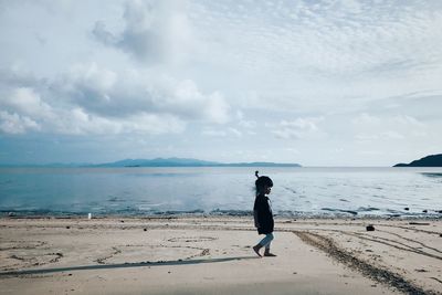 Full length of woman on beach against sky