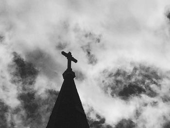 Low angle view of weather vane against sky