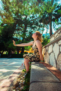 Full length of woman sitting on tree