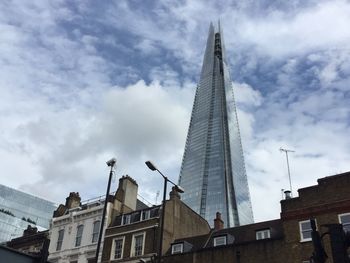 Low angle view of modern building against cloudy sky