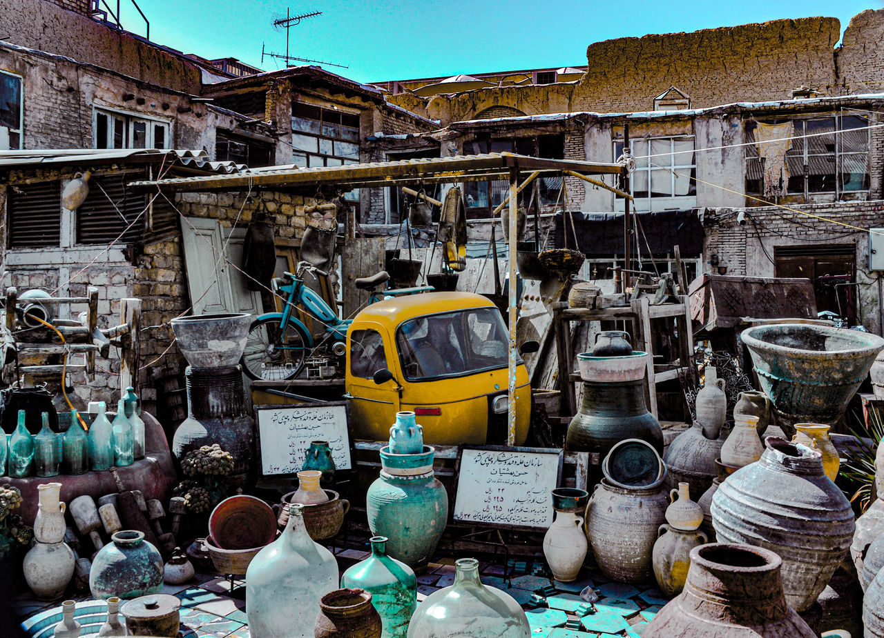 city, market, vehicle, architecture, day, public space, no people, large group of objects, building exterior, abundance, built structure, outdoors, car, urban area, nature, transportation, mode of transportation, travel, land vehicle