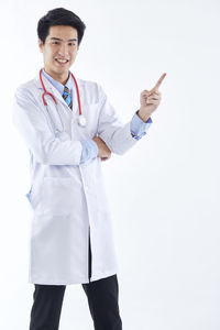 Smiling young woman standing against white background
