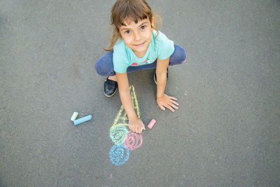 High angle view of girl drawing on road