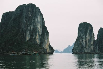 Panoramic view of sea and rocky mountains against clear sky