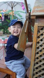 Portrait of smiling boy holding wood