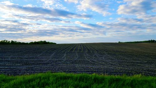 Scenic view of field against cloudy sky