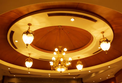 Low angle view of illuminated chandelier hanging from ceiling