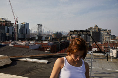 Woman against buildings in city against sky