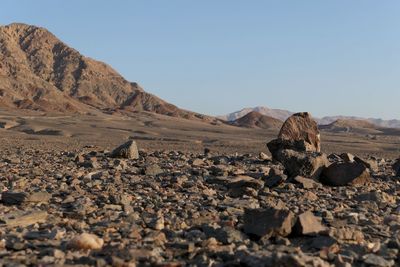 Surface level of rocks on land against clear sky