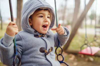 Cute boy enjoying on swing at playground