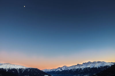 Scenic view of snowcapped mountains against clear sky at night