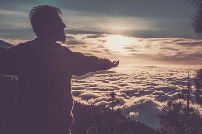 Rear view of man looking at sea against sky