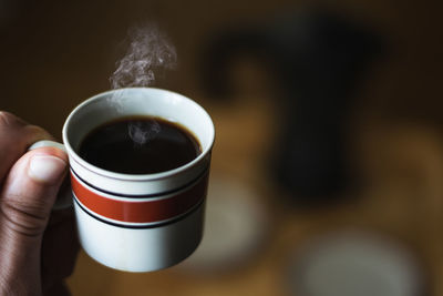 Close-up of hand holding coffee cup