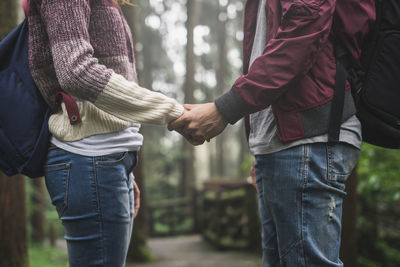 Midsection of couple holding hands