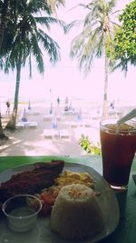 Close-up of drink on table at beach