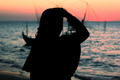 Silhouette woman at beach during sunset