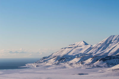 Snowcapped mountains against clear blue sky