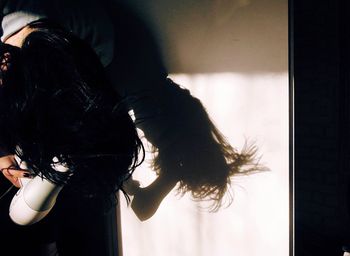 Woman drying hair at home