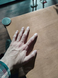 High angle view of person hand on table