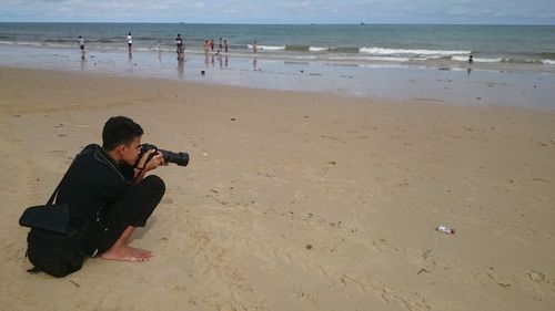 Man photographing on beach