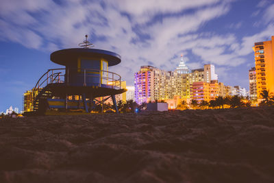 Water tower on beach against sky at dusk