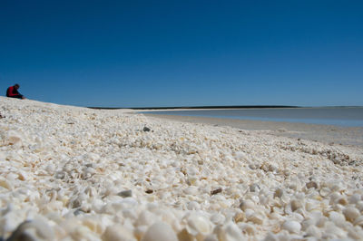 Scenic view of beach against clear blue sky