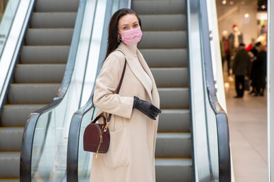 Young woman standing on escalator