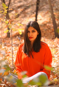 Portrait of young woman sitting on field
