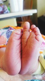 Low section of baby feet on bed