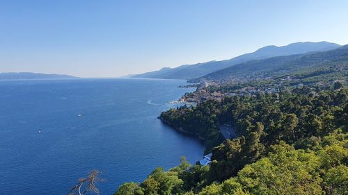 High angle view of townscape by sea against clear sky