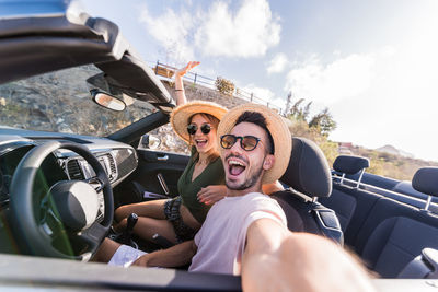 Portrait of cheerful couple in car